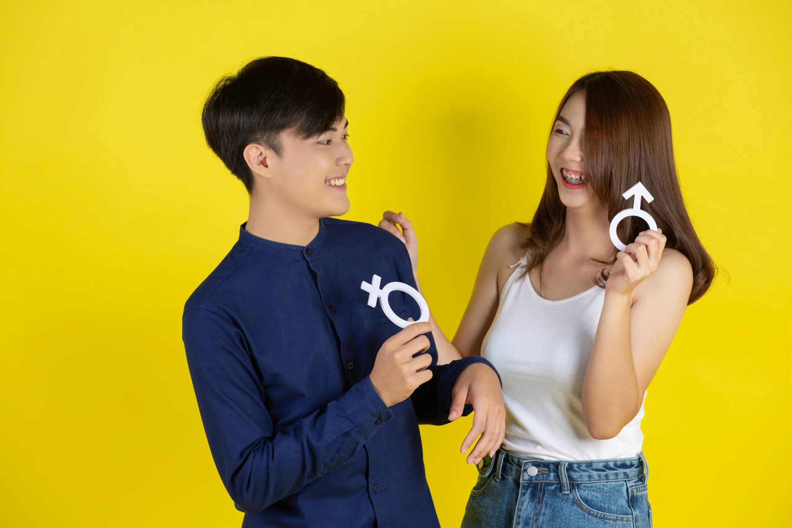 pria dan wanita memegang simbol maskulin dan feminim