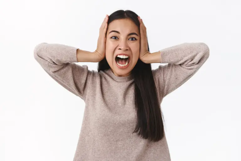 Seorang wanita yang memegang kepala nya karena mengalami serangan panik